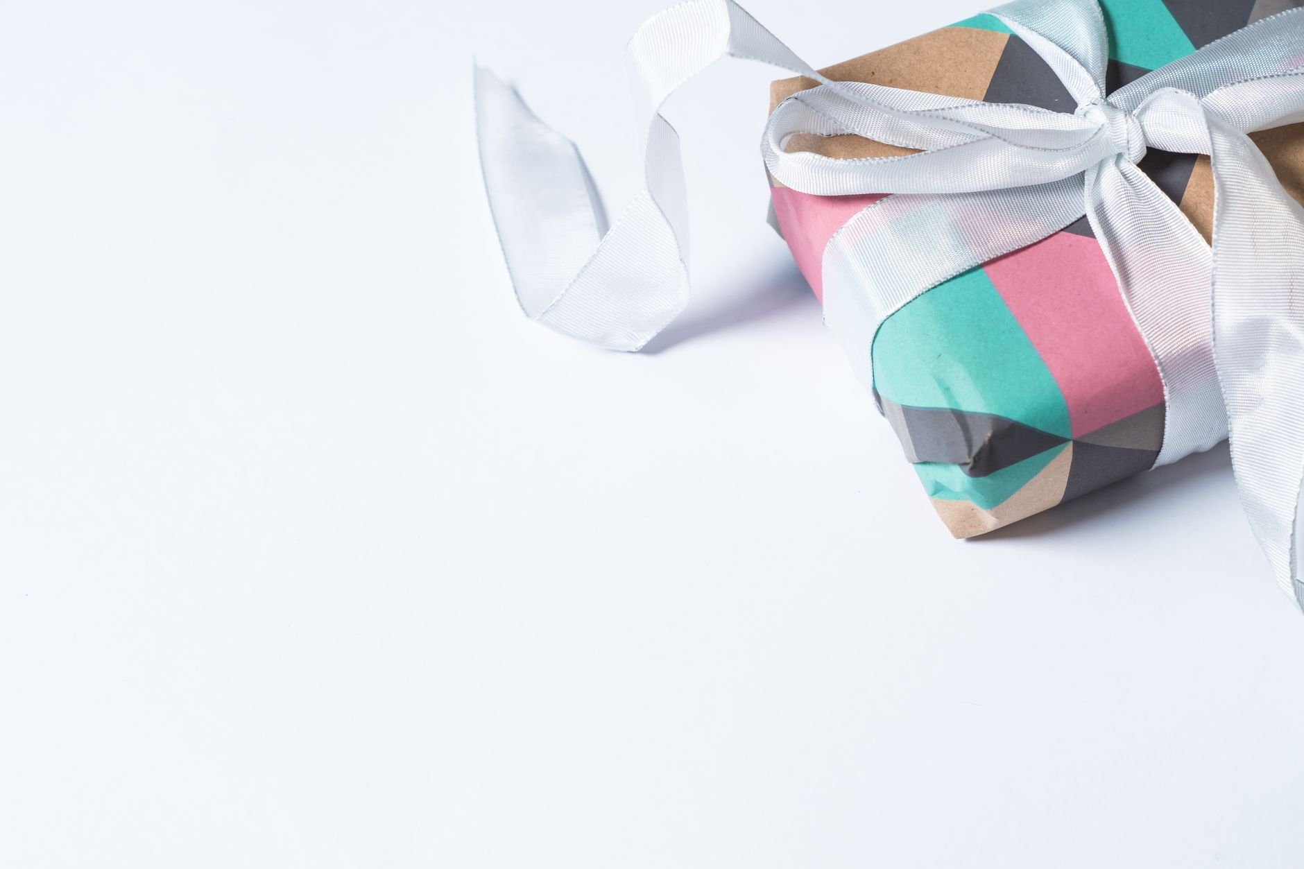 A colorful gift box wrapped with white ribbon